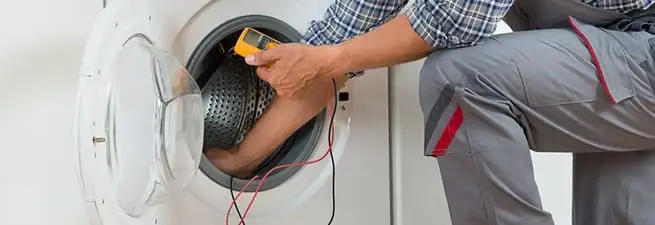 Dryer repair technician inspecting and repairing a clothes dryer in Salt Lake City, UT