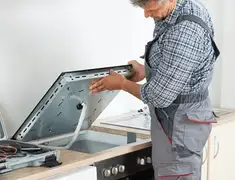 Appliance repair technician installing a built-in cooktop in Salt Lake City, UT