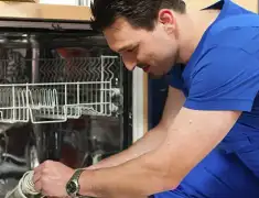 Dishwasher repair technician inspecting and servicing an open dishwasher in Salt Lake City, UT