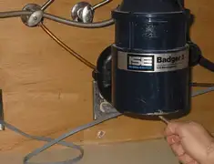 Garbage disposal repair technician tightening the mounting ring under a sink in Salt Lake City, UT