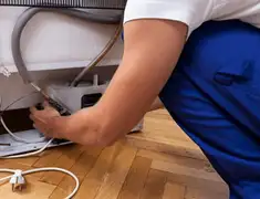 Appliance repair technician fixing refrigerator water line and connections in Salt Lake City, UT