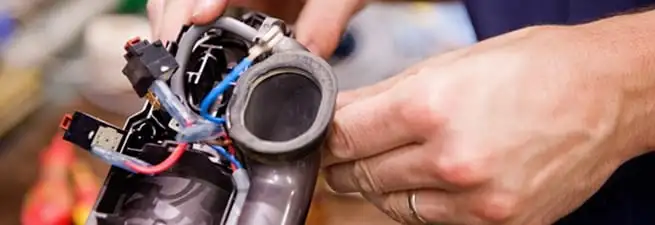 Vacuum repair technician reconnecting wiring and components in Salt Lake City, UT
