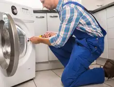 Washing machine repair technician servicing a front-load washer in Salt Lake City, UT