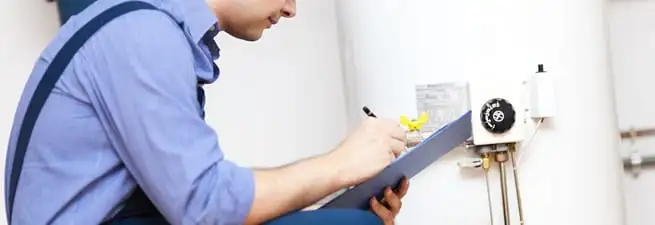 Water heater repair technician inspecting the unit and recording service notes in Salt Lake City, UT