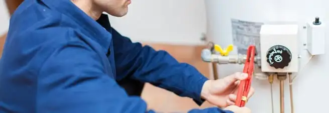 Water heater repair technician adjusting the temperature control and gas valve in Salt Lake City, UT